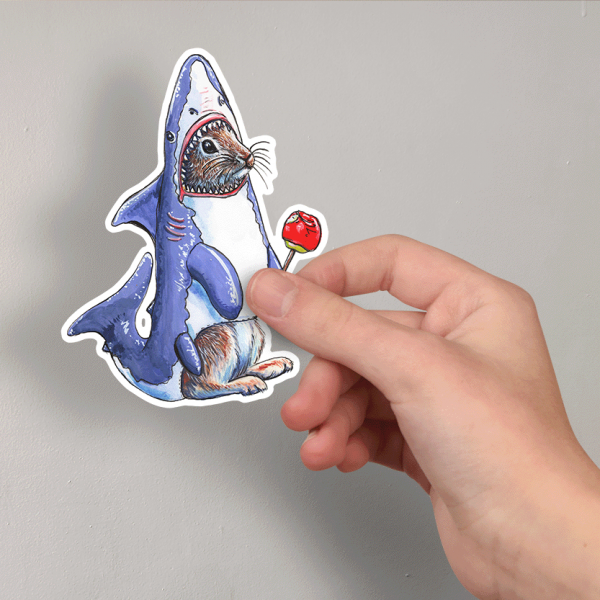 Illustration of a rabbit in a shark costume with a red candy apple - on a sticker in a hand