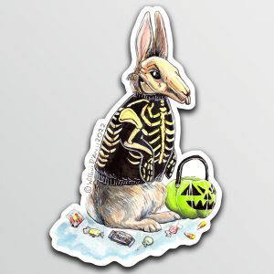 Sticker of an illustration of a rabbit wearing a skeleton costume with a plastic Jack O’Lantern candy bucket and candy scattered around them.