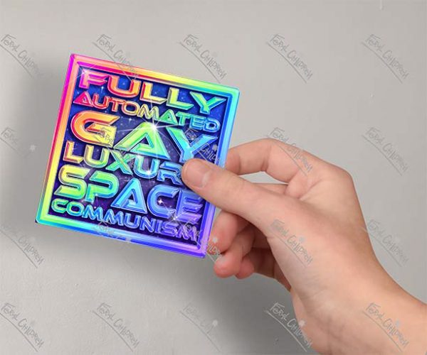 A glossy sticker of a rainbow logo with the phrase "Fully Automated Gay Luxury Space Communism" in a shiny 3d futuristic styled font.