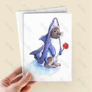 Rabbit wearing a shark costume and holding a red candy apple - on a greeting card held in a hand